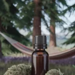 A bottle of cedarwood essential oil with cannabis buds on a tree stump in the forest. In the background is a hammock.