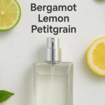 A bottle of perfume next to lemon and bergamot fruits.