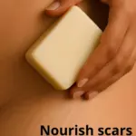A woman's hand holding a stretch mark balm bar.