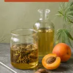 Editorial formulation photograph showing golden apricot kernel oil in two clear glass vessels, with cannabis flowers visible in one, beside whole and halved apricots, loose kernels and cannabis leaves. Text reads Apricot Kernel Oil: A Lighter Oil for Cannabis Infusions, with 420formulator.com below.